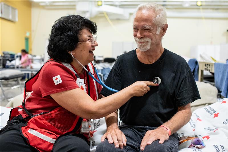 Photo of Red Cross worker and patient at a health screening.
