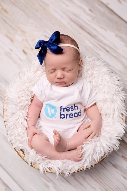 Photo of newborn baby in a "Fresh Bread" onesie