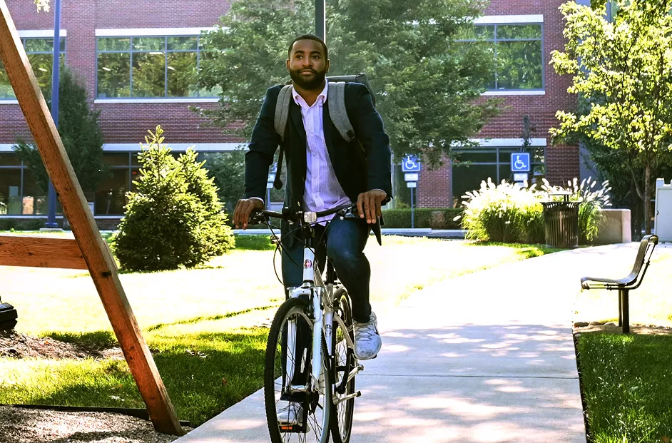 A man rides a bike through the Bread Financial outdoor courtyard.