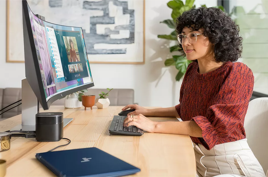 Female sits at her ask while doing work at the computer.