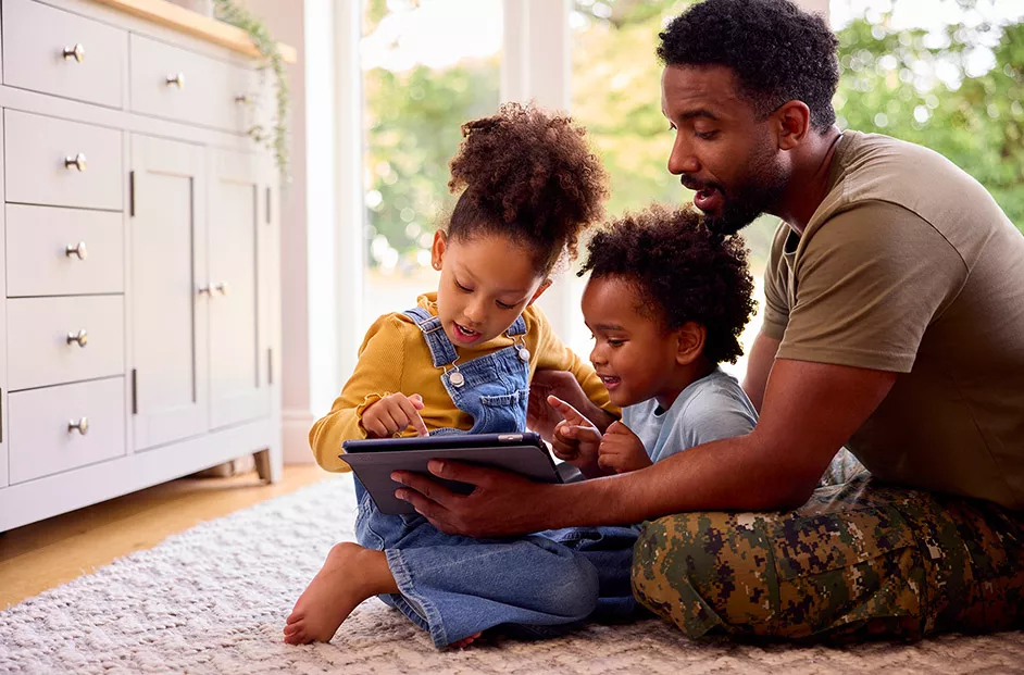 Photo of a miliary father reading to his children.
