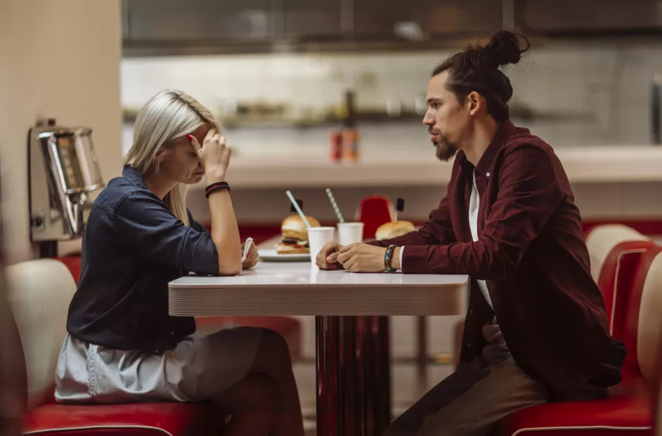 Depressed couple eating a meal at a diner