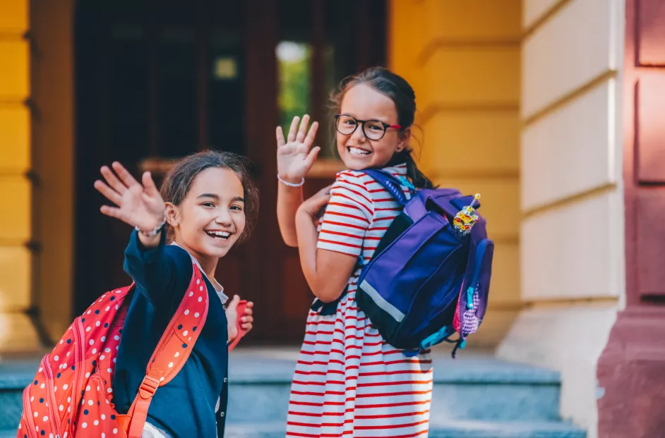 Schoolgirls smiling before entering the school building