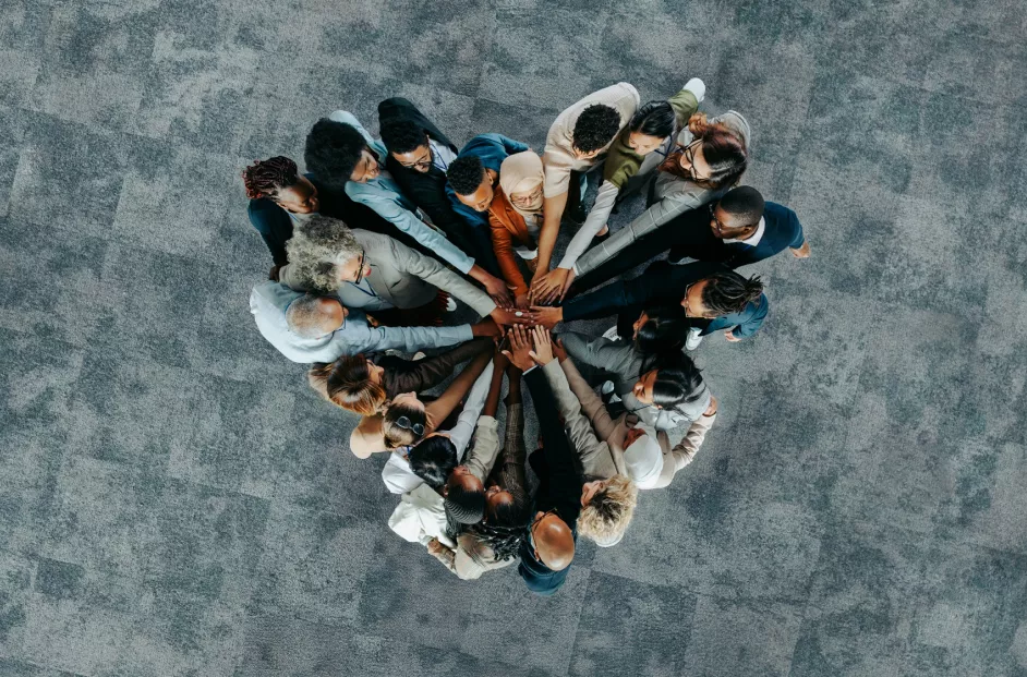 A diverse business group standing in a heart formation, symbolizing unity, teamwork, and collaboration.