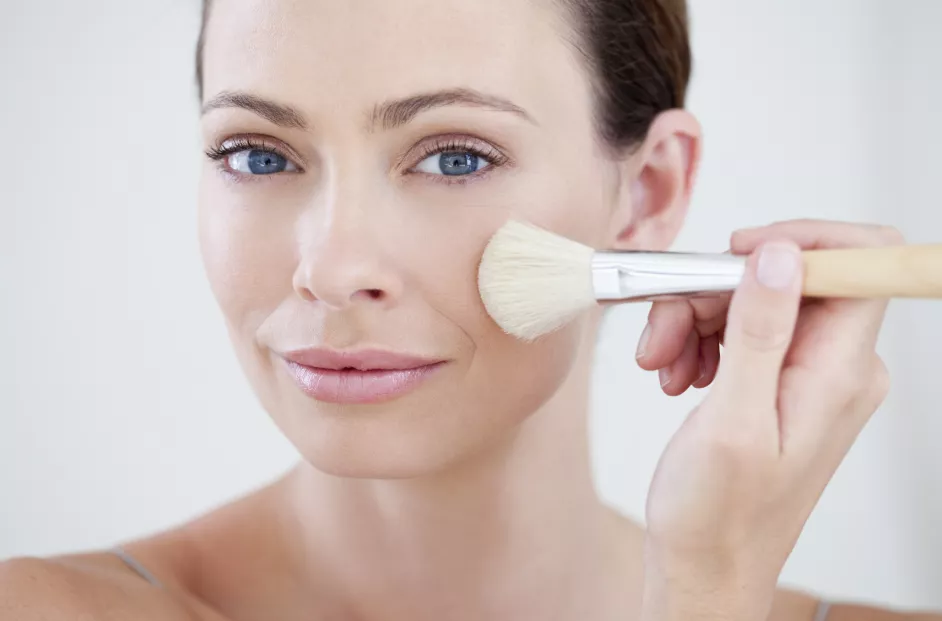 Woman applying make-up with brush