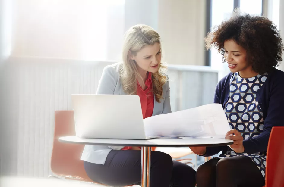 Two women review documents.