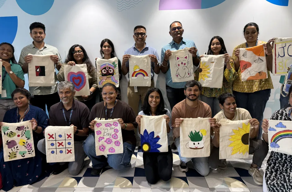 Bread Financial associates in India display tote bags created for a volunteer project.