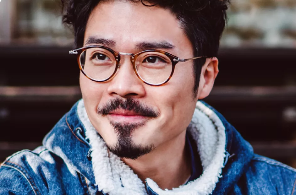 man smiling while holding a phone