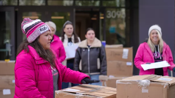 ROX program facilitators carry boxes of clothing at the recent distribution event at Bread Financial's Columbus headquarters.
