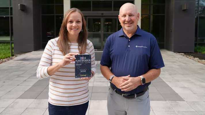 Lindsay Madaras, senior manager of associate well-being, and Perry Beberman, executive vice president and chief financial officer, pictured with the PlanSponsor of the Year Award at Bread Financial's Columbus, Ohio office.