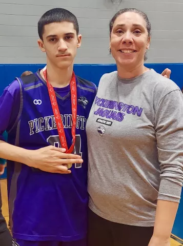 Tez Reardon and her son Tyson, pose for picture after a basketball game. Tyson is wearing a medal.