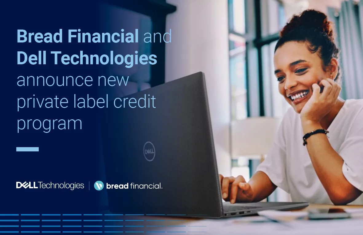 A woman smiles while using her Dell laptop.