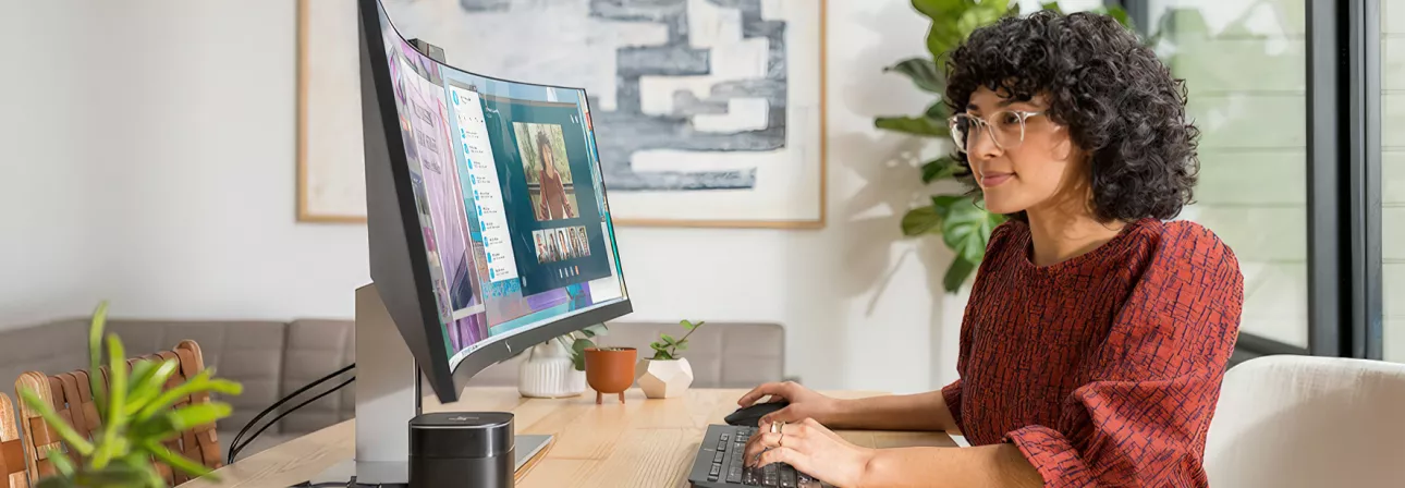 Female sits at her ask while doing work at the computer.