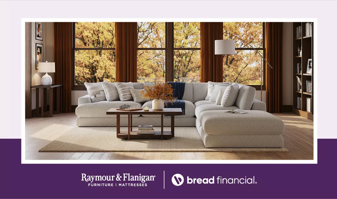 Stock image of a well decorate living room with fall foliage featured in the window in the background. A lockup of the Bread Financial and Raymour & Flanigan logos is included.