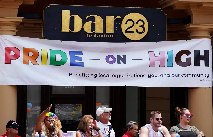 Banner display with Pride on High in colors of the rainbow.