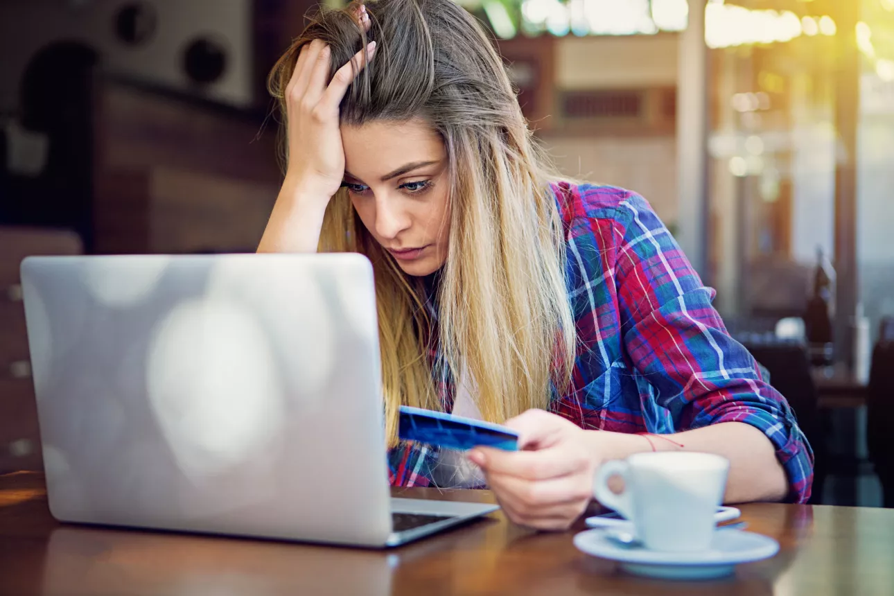 Depressed young girl with empty account is trying to shopping online