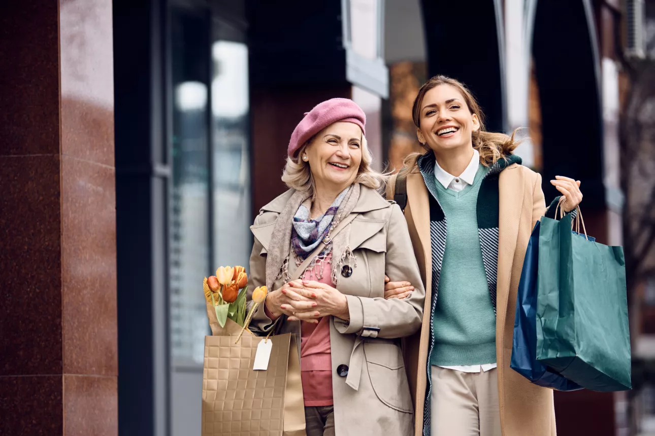 Cheerful mother and daughter enjoying in shopping day in the city.
