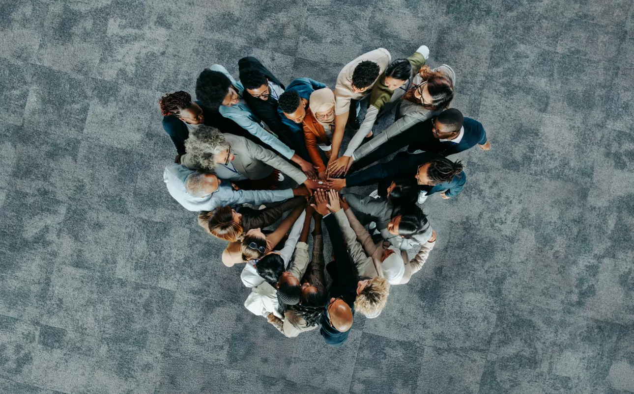 A diverse business group standing in a heart formation, symbolizing unity, teamwork, and collaboration.